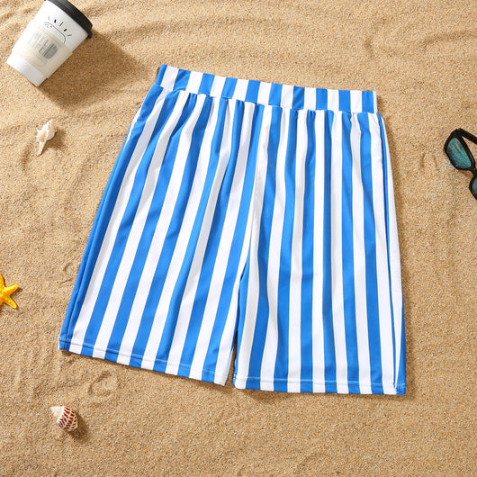 Blue and white striped one-piece swimsuit with a bow detail on the bust, laid on sand with sunglasses. - Image 6