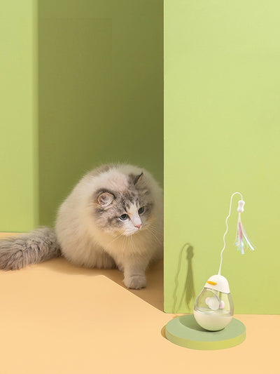 Yellow duck egg shaped tumbler cat toy with a clear middle, containing a yellow ball, and a flexible wand with purple and pink streamers. - Image 10