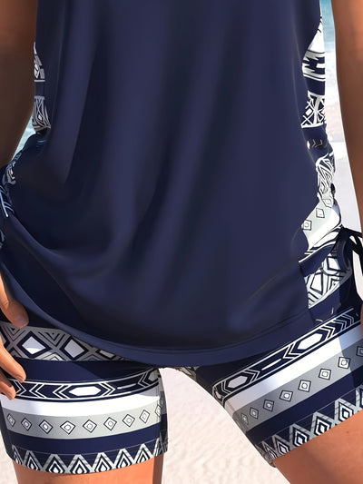 Women's navy blue tankini swimsuit with geometric pattern, criss-cross V-neck, and matching swim shorts. - Image 15
