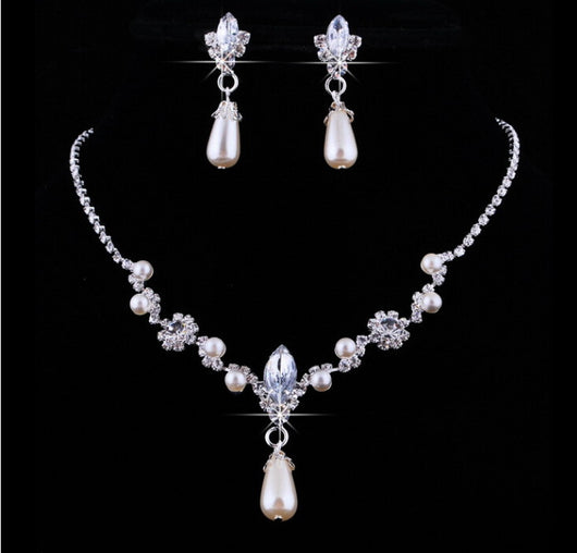 Purple rhinestone and faux pearl necklace and drop earrings set on a black display. Features silver-tone settings. - Image 3
