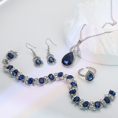 Light luxury jewelry set with silver-tone necklace, dangle earrings, open ring, and bracelet, all featuring emerald green teardrop and oval stones with clear rh - Image 7