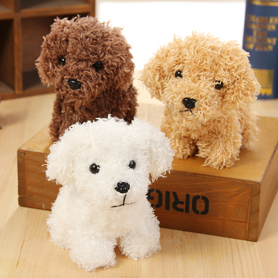 Small brown fluffy plush toy resembling a poodle or teddy dog, with black button eyes and nose, sitting.