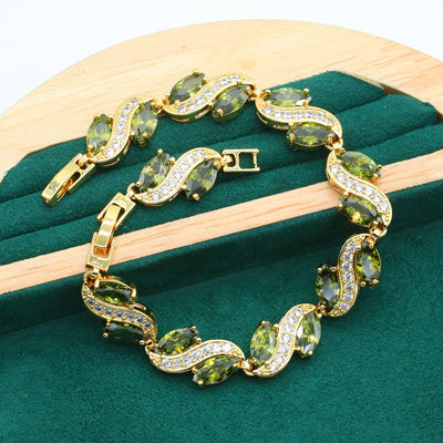 Gold-toned jewelry set with green marquise gemstones and clear accents, including a bracelet, necklace, earrings, and ring. - Image 12
