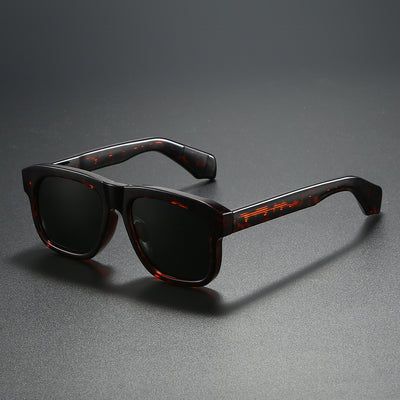 Black square-frame polarized sunglasses with dark lenses, suitable for both men and women, on a dark gray surface.