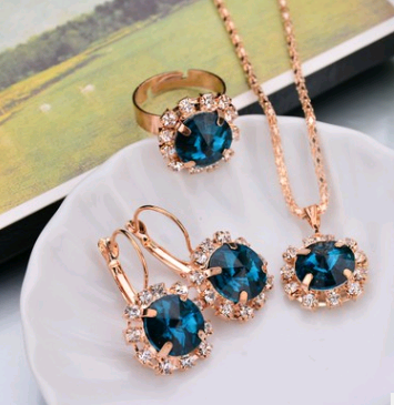 Rose gold-toned necklace, earrings, and ring set with large oval clear gemstones surrounded by smaller stones. - Image 23