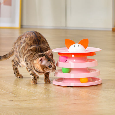 Brown tabby cat sniffing a black and orange multi-level rotating cat plate toy with colorful balls and bunny ears. - Image 3