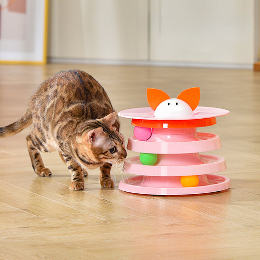Brown tabby cat sniffing a black and orange multi-level rotating cat plate toy with colorful balls and bunny ears. - Image 3