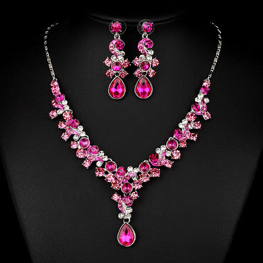 Pink and red rhinestone necklace and matching drop earrings set, featuring teardrop gems and floral scroll design. - Image 2