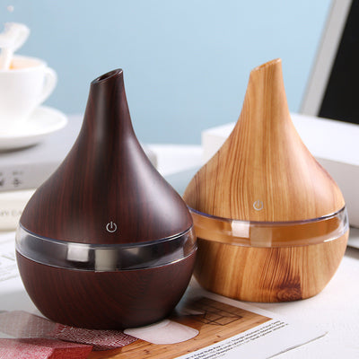 Teardrop-shaped humidifier with light wood grain finish and clear water tank, featuring a power button icon. - Image 2