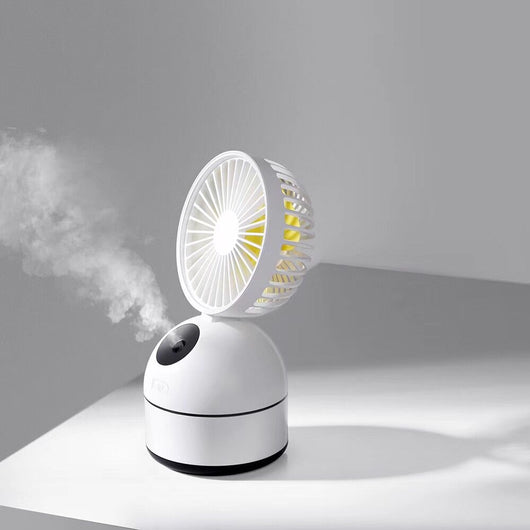 Dark grey fan humidifier with a round fan head and spherical base, emitting mist, on a white desk. - Image 9