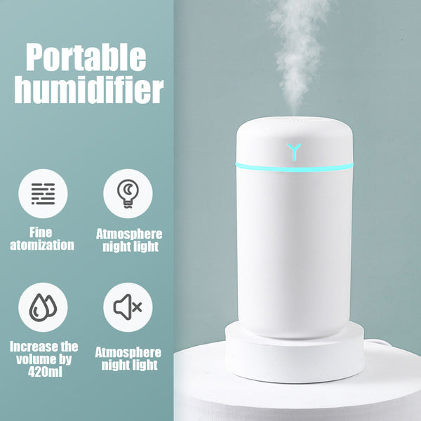 Pink portable humidifier with a blue LED light band, emitting fine mist, on a white pedestal. - Image 5