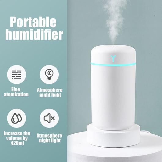 Pink portable humidifier with a blue LED light band, emitting fine mist, on a white pedestal. - Image 5