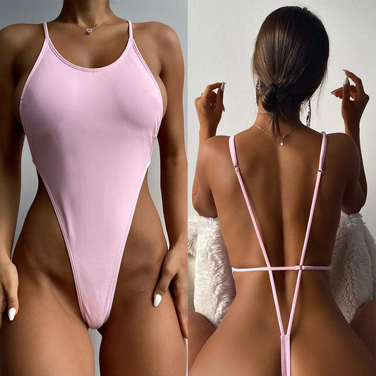 Light pink one-piece swimsuit with thin spaghetti straps and a high-cut leg design, worn by a woman.