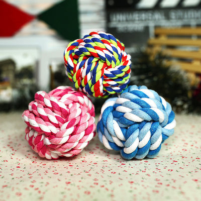 Pink and white braided cotton rope ball pet toy for dogs, designed for chewing and play.