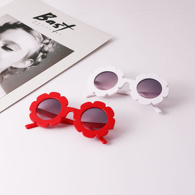 Light blue flower-shaped sunglasses with dark lenses, featuring a playful design and plastic frame. - Image 3