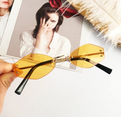 Retro oval vintage sunglasses with orange hexagonal lenses and gold-tone metal temples, held by a hand. - Image 8