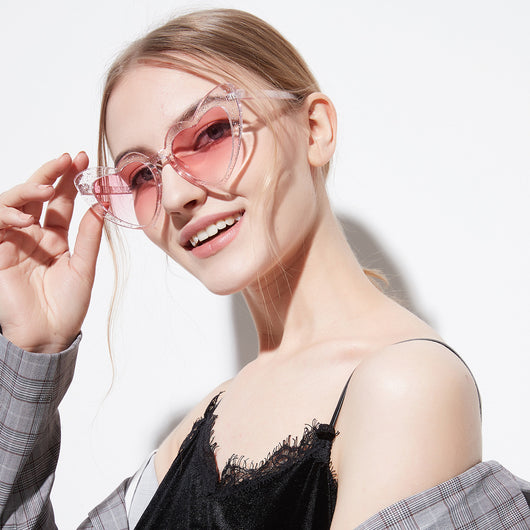 Light gray heart-shaped sunglasses with dark lenses, featuring a vintage-inspired plastic frame.