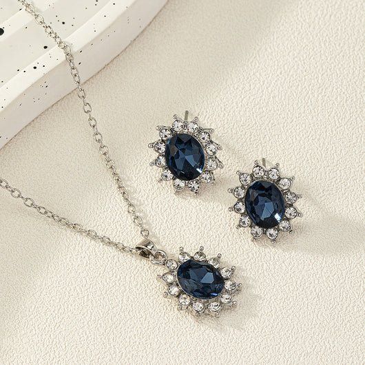 Iridescent teardrop pendant necklace with matching stud earrings, featuring clear accent stones and silver-tone metal.