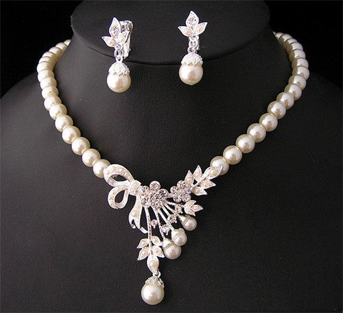 Three-piece pearl jewelry set with multi-strand necklace, bracelet, and drop earrings, all featuring sparkling rhinestone flower accents. - Image 5