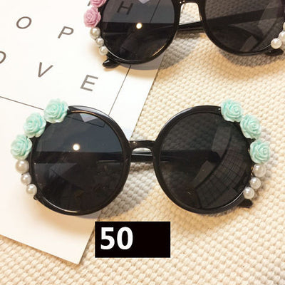 White round sunglasses with daisy flower embellishments on the frames and dark gradient lenses. - Image 27