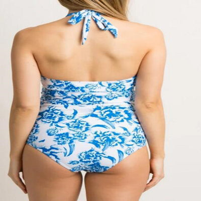 Women's blue and white floral print halter neck tankini top with ruched bottoms on a sandy beach. - Image 5