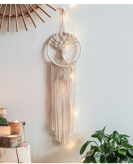 Handmade macrame dream catcher with a tree of life design, natural cotton rope, and a light green stone accent.