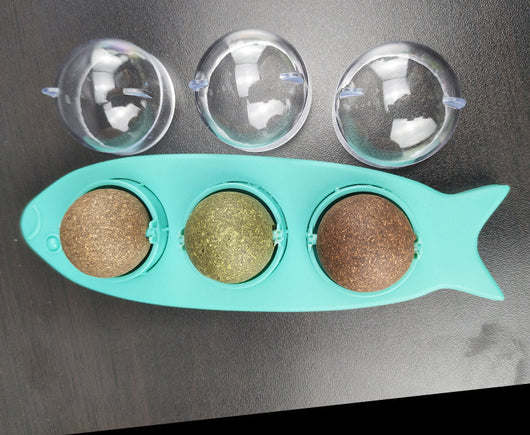 Pink fish-shaped cat molar stick toy with three compartments holding green and brown catnip or silvervine balls. Three clear plastic dome covers are shown. - Image 7