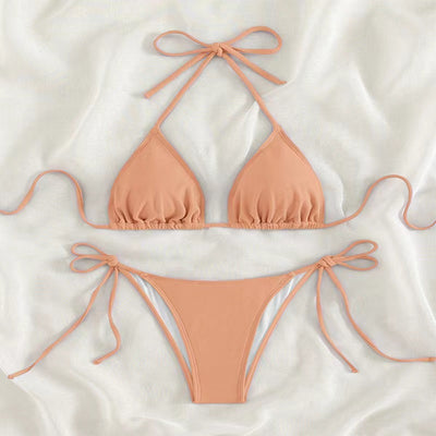 Neon yellow halter bikini with triangle top and tie-side bottoms, displayed on a light wood surface. - Image 32