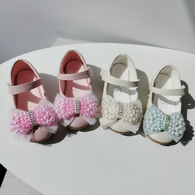 Beige girls' princess shoes with pearl and rhinestone bows, featuring a flat heel and a convenient Velcro strap. - Image 4