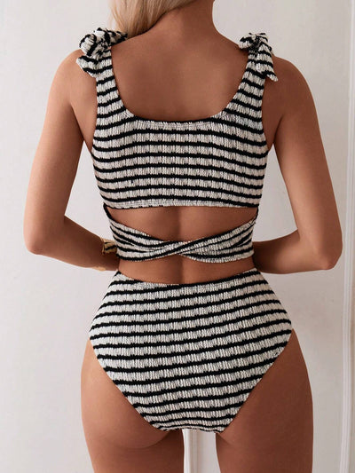 Women's black and white striped two-piece swimsuit with a tube top and high-waisted bottoms, worn by a person lounging on a white bed. - Image 9