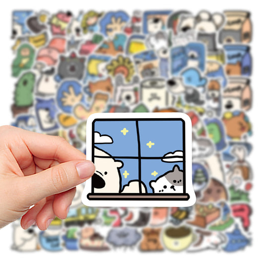 Hand holding a cartoon sticker of a dog and cat looking out a window at a starry night, with many other animal stickers blurred in the background. - Image 7