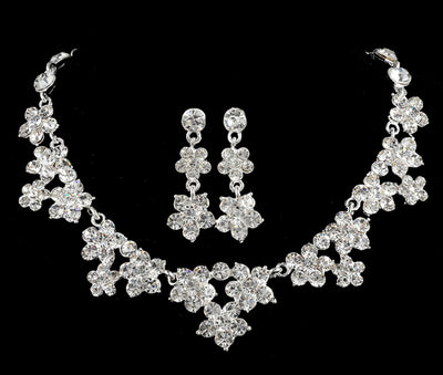 Sparkling crystal bridal jewelry set with floral necklace, drop earrings, and a matching tiara on a bride. - Image 2
