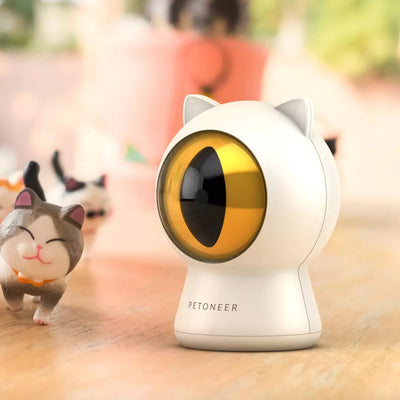 White cat-shaped laser toy with gold eye and red light, alongside a light blue smart rolling ball cat toy.