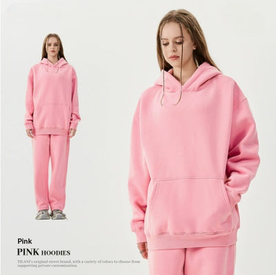 Young woman wearing a pink fleece-lined hoodie and matching sweatpants tracksuit set with a drawstring hood and kangaroo pocket. - Image 19