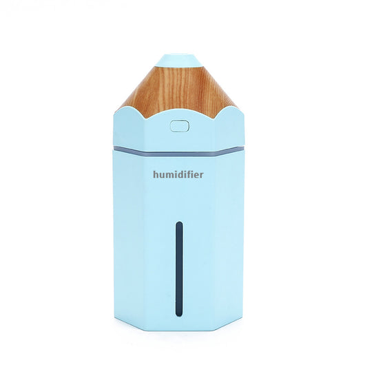 Light blue pencil-shaped mini humidifier with wood-grain top and glowing green light, next to a white teacup and pink gift box.