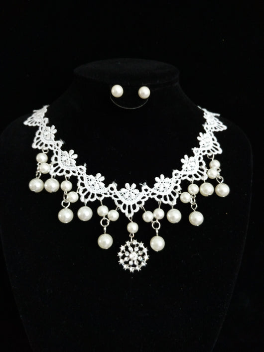 White lace and pearl necklace set with matching stud earrings, featuring a snowflake pendant, on a black display. - Image 2