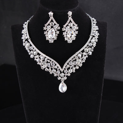 Sparkling silver-tone necklace and matching earrings set with clear round and teardrop rhinestones on a black display. - Image 3