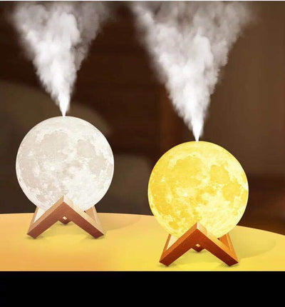 Moon-shaped night light and air humidifier on a wooden stand, emitting mist and a warm glow, with books and flowers.