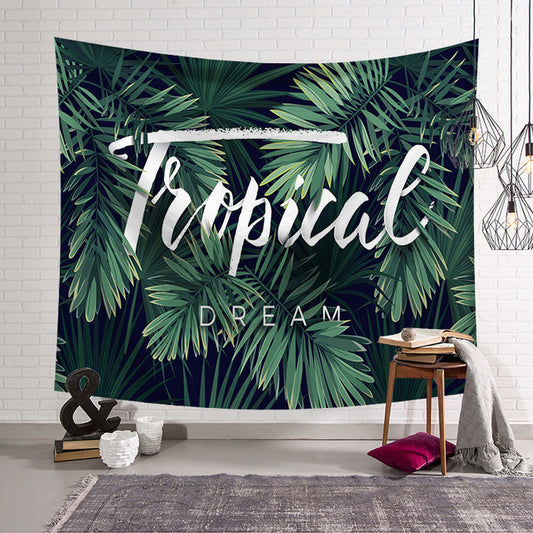 Tropical Dream tapestry with green banana leaves on a dark blue background, hanging on a white brick wall.