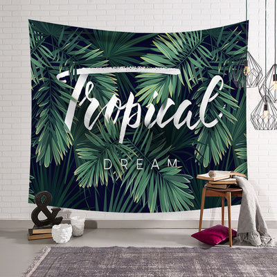 Tropical Dream tapestry with green banana leaves on a dark blue background, hanging on a white brick wall.