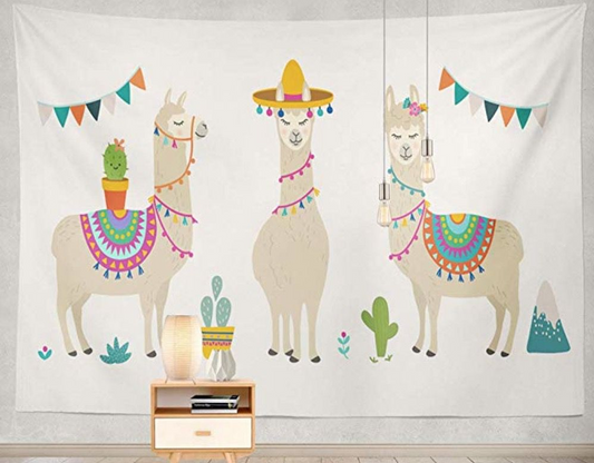 White tapestry featuring three cartoon llamas with colorful saddles, a sombrero, flowers, cacti, and mountains.