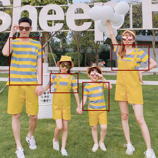 Family of four wearing matching yellow and blue striped t-shirts with daisy appliques. Mother and daughter wear yellow short overalls, father and son wear yello