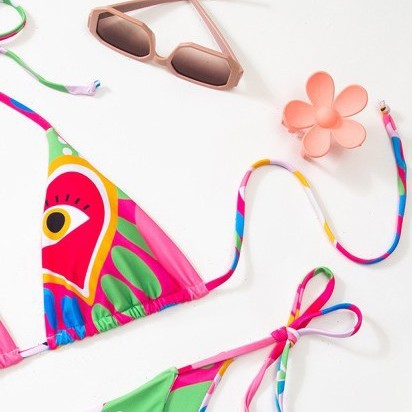 Women's vibrant abstract eye print bikini with triangle top and tie-side bottoms, featuring pink, green, and blue. - Image 2