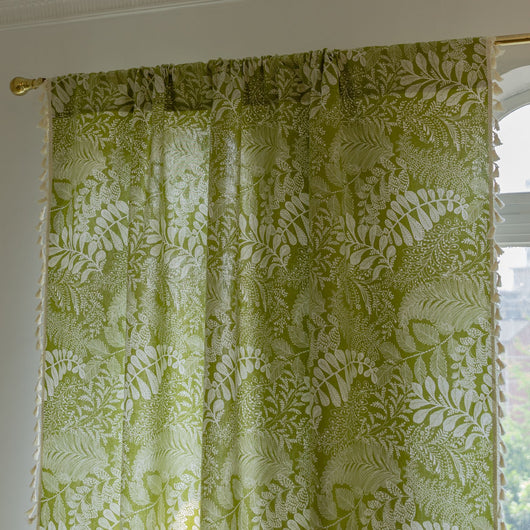 Green curtain with white leafy botanical pattern and cream tassels, hanging in a window with natural light. - Image 13