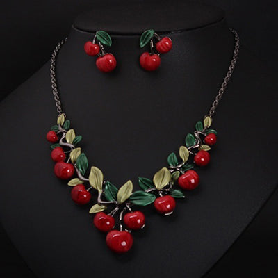 Cherry necklace and earring set featuring red enamel cherries and green leaves on a dark chain, displayed on a black bust. - Image 6