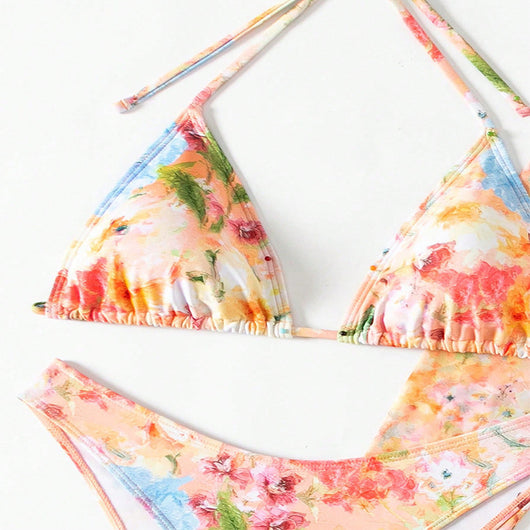 Four-piece women's beachwear set with a peach, blue, and green floral print. Includes a triangle bikini, long-sleeve tie-front cover-up, and ruched mini skirt. - Image 19