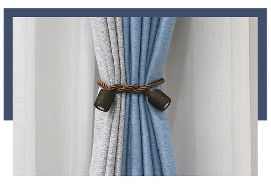 Black cylindrical magnetic curtain tieback holding a light blue pleated curtain, against a clean white background. - Image 13