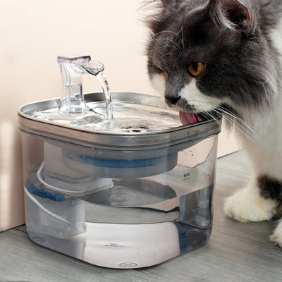 Automatic pet water fountain with clear reservoir, stainless steel top, and flowing water spout, shown with power adapter and filter set. - Image 13