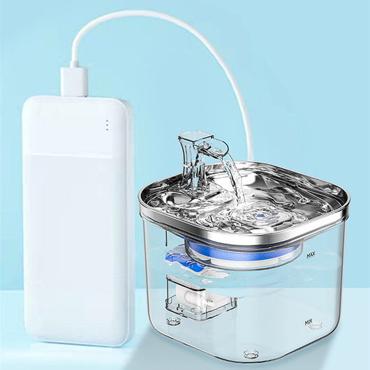 Automatic pet water fountain with clear reservoir, stainless steel top, and flowing water spout, shown with power adapter and filter set. - Image 16