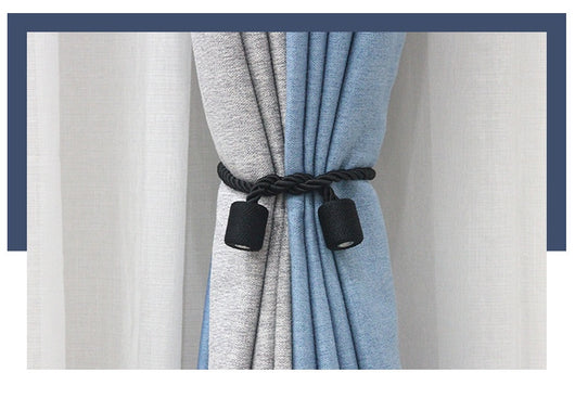 Black cylindrical magnetic curtain tieback holding a light blue pleated curtain, against a clean white background. - Image 28